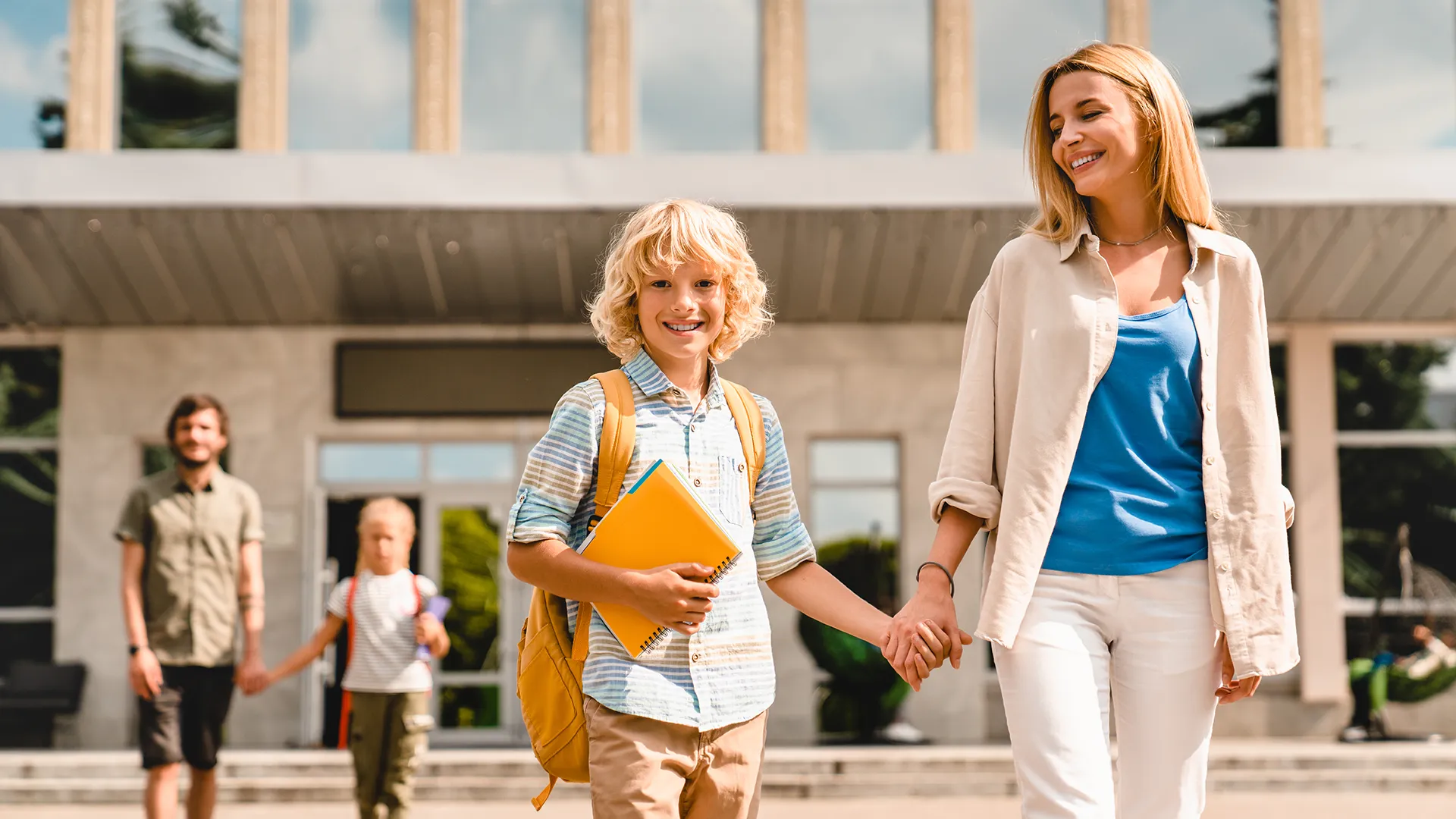 Mamma e figlio che escono da scuola felici